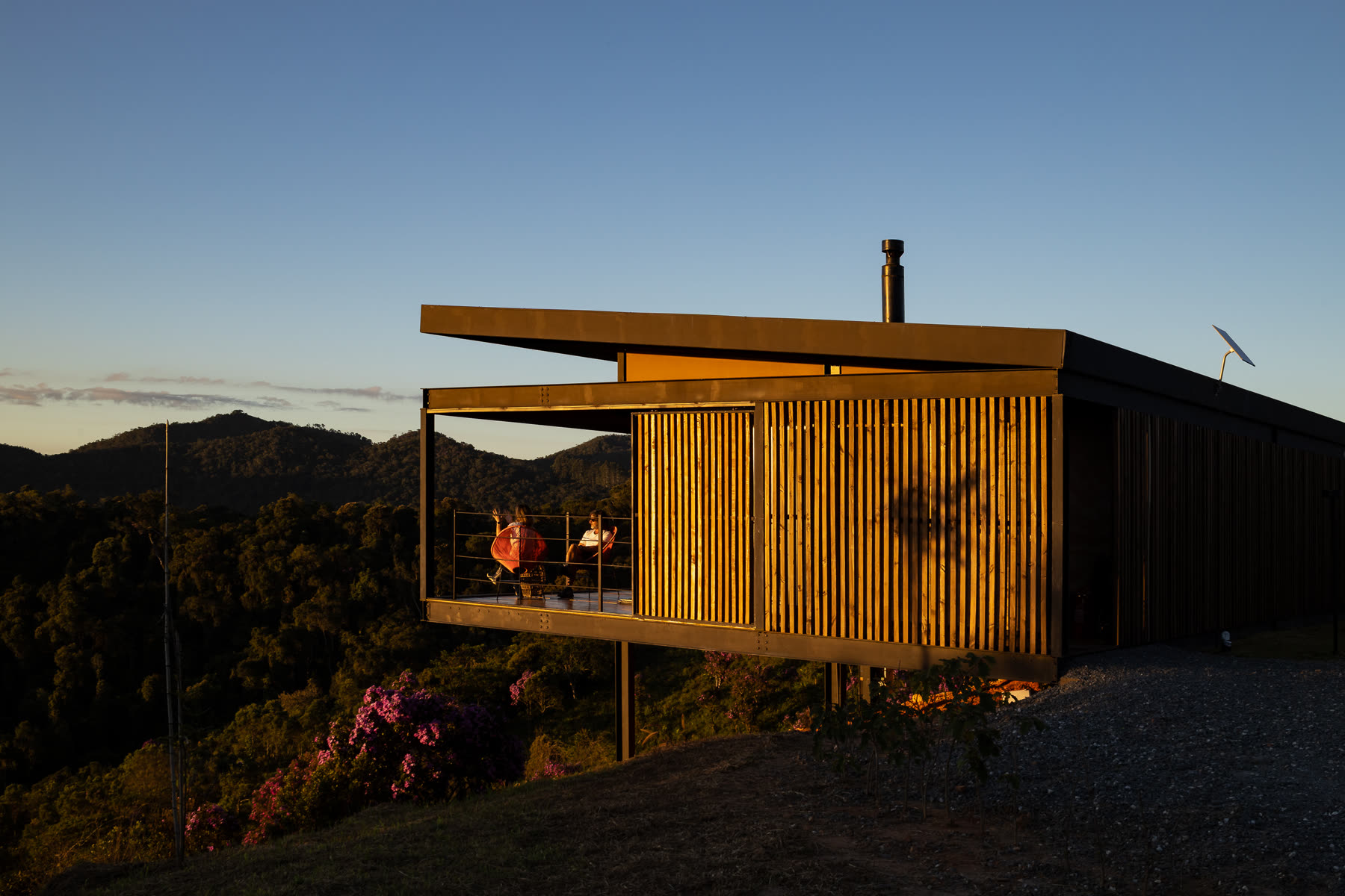 A casa ao pôr do sol com a varanda acesa em balanço